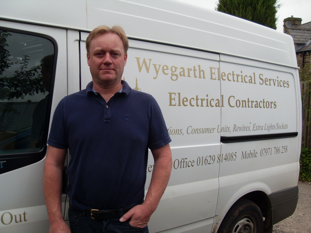 Standing beside the white Wyegarth Electrical Services van with its gold lettering